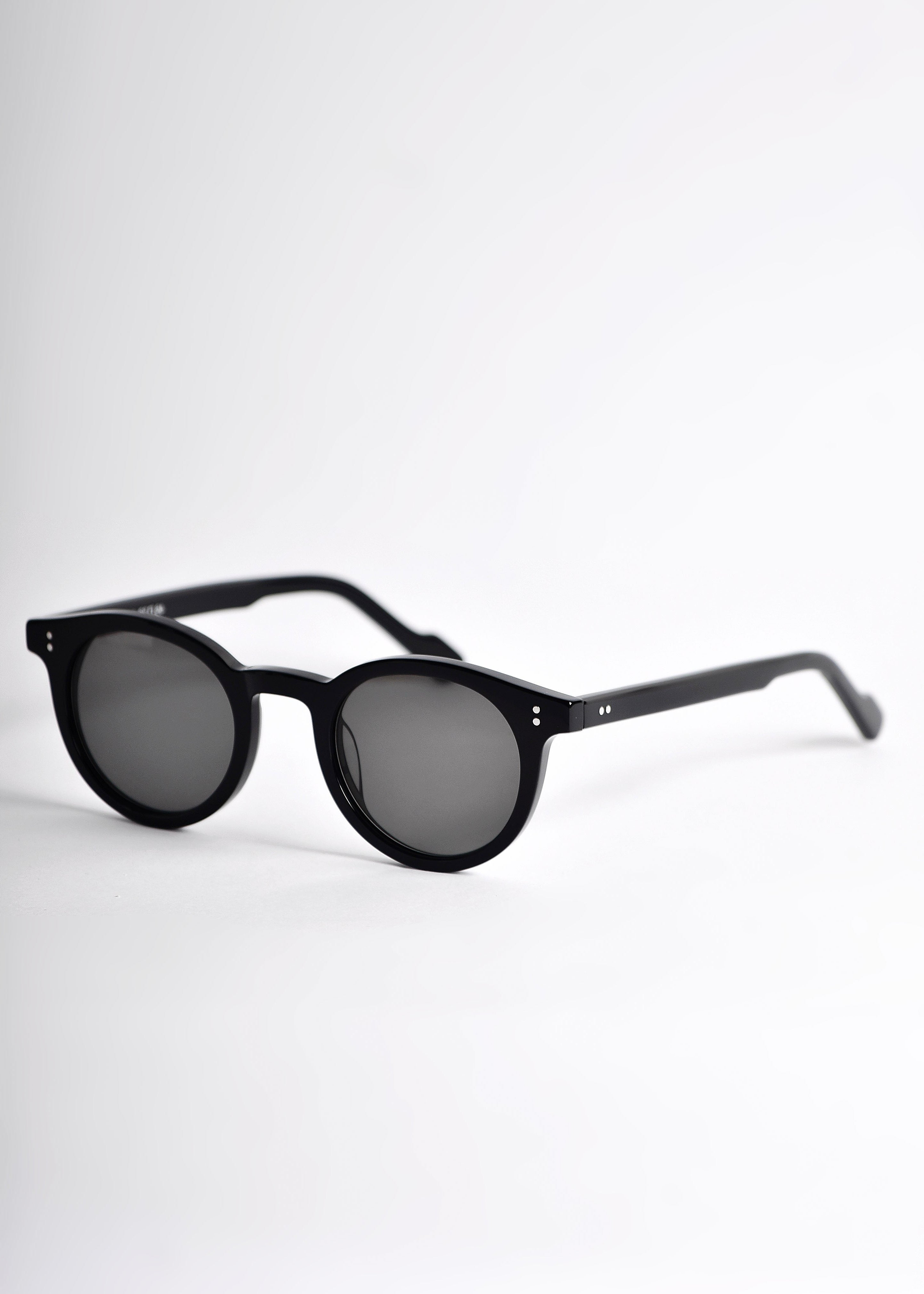 Black sunglasses with dark lenses on a white background